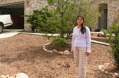 
                    Arshia Khurshid stands in her front yard, where she has replaced a grass lawn with rocks, mulch and trees.
                                            (Michael May)
                                        