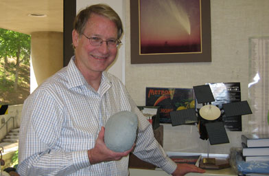 
                    Don Yoemans, head of NASA's Near Earth Object monitoring program, holds a model of his favorite near earth object--an asteroid that is really several kilometers wide.  This one is not scheduled to make impact with the earth, but it will pass by "the neighborhood."
                                            (Krissy Clark)
                                        
