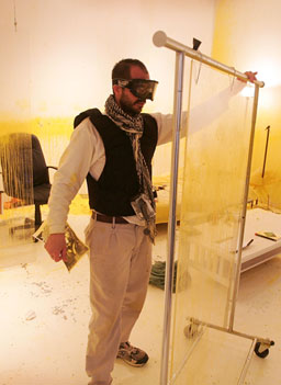 
                    Bilal protects himself using a portable Plexiglas shield. Bilal hopes to draw attention to the intensity of daily life in Iraq as he spends his days and nights trying to avoid being shot.
                                            (Scott Olson / Getty Images)
                                        