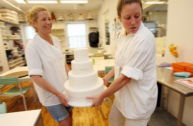 
                    Karin Batchelor (left) and Ellie Larson of Ron Ben-Israel Cakes carry a cake that will be used in a 7/7/07 wedding July 6, 2007 in New York City. Wedding planners say a flood of couples are marrying on 7/7/07 due to the numerical and superstitious significance of the date.
                                            (Mario Tama / Getty Images)
                                        