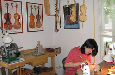 
                    Klein works on a violin while the others hang behind her.
                                            (Sarah Lemanczyk)
                                        