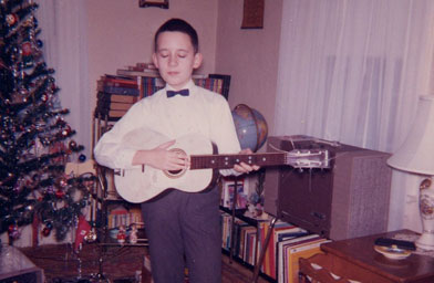 
                    Author Luc Sante with his new guitar in Christmas 1964. Sante's treasured "The New Christy Minstrels" album is at his feet.
                                            (Luc Sante)
                                        