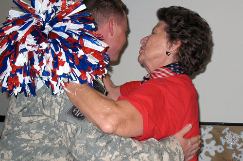 
                    But before anyone greets the soldiers, volunteer Linda Tinnerman gives them a hug.
                                            (Julia Barton)
                                        