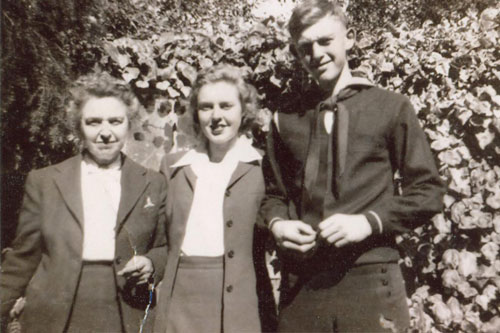 
                    Krissy Clark's father, Lester Clark, in his navy uniform, sometime during World War II.  His sister and mother are beside him.
                                            (Krissy Clark)
                                        
