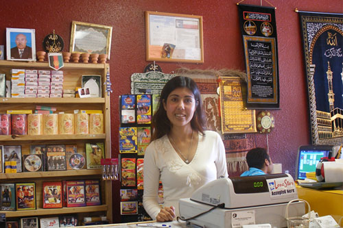 
                    Mariya Sher Ali works behind the counter at her store, Amarillo International Food.  The store caters to Amarillo's growing refugee population and stocks foods from all over the world.  It also rents Bollywood movies.
                                            (Ann Heppermann and Kara Oehler)
                                        