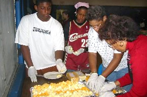 
                    (From Left to right) Weekend America Host Desiree Cooper's son Jay, her daughter Rae, an unidentified woman and her mother prepare a Thanksgiving meal for the homeless at Cass United Methodist Church in Detroit in November, 2004.
                                            (Courtesy Desiree Cooper)
                                        