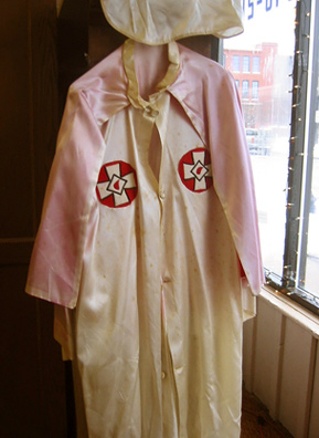 
                    This robe was one of a collection of items from the estate of the late Robert E. Miles auctioned off in Howell, Mich., in 2005. Miles was a grand dragon in the Ku Klux Klan. The auction garnered national interest and helped cement Howell's reputation as a KKK town.
                                            (Desiree Cooper)
                                        