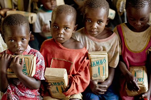 
                    Orphans hold packs of flour distributed to them by a businessman in a Kenyan church. The young children's parents were victims of widespread violence that has swept the country since disputed elections sparked simmering tensions in the country on Dec. 27, 2007.
                                            (Yasuyoshi Chiba/AFP/Getty Images)
                                        