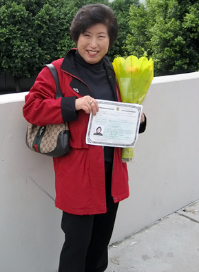 
                    Kyong Kim, mother of Weekend America associate producer Angela Kim, stands outside of the Los Angeles Convention Center holding her naturalization certificate after her citizenship ceremony.
                                            (Angela Kim)
                                        