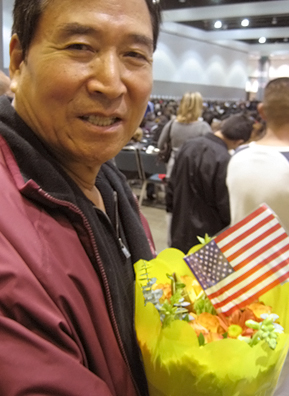 
                    Angela's father, Jong, waits for the ceremony to begin. On the day of the event, people entering the building are split up into "new citizens" and "guests." New citizens funnel inside and take their seats where they recite the loyalty oath and receive their naturalization papers.
                                            (Angela Kim)
                                        