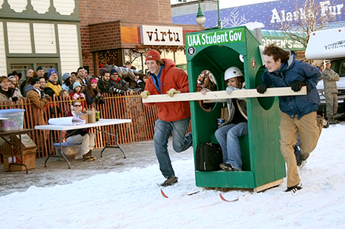 
                    University of Alaska Anchorage students (the back of their outhouse reads "We're #1...and #2!) race down Anchorage's Fourth Avenue during the Fur Rendezvous Outhouse Races.
                                            (Anchorage Convention &Visitors Bureau/Cady Lister)
                                        