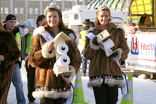 
                    The Fur Rendezvous Princesses parade the fabulous Outhouse Race trophies before the contest begins.
                                            (Photo Credit: Anchorage Convention &Visitors Bureau/Cady Lister)
                                        