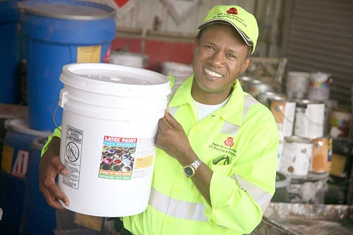
                    Ousmane Sy holds a bucket of recycled paint. Like Sy, many of Sunset Scavengers employees are foreign-born.
                                            (Courtesy Sunset Scavenger Recycling Center)
                                        