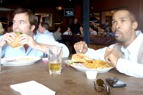 
                    Weekend America correspondent Charlie Schroeder and co-worker Horace Washington enjoy burgers while watching the NCAA championship games. When it comes to filling out their brackets, Schroeder goes with his gut, while Horace relies on a complex system of statistics and numbers to make his picks.
                                            (Courtesy Charlie Schroeder)
                                        