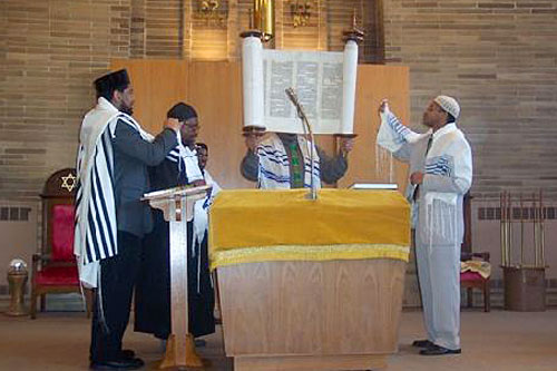 
                    Rabbi Capers Funnye and the assistant rabbis hold the Torah at a recent Saturday service at Temple Beth Shalom in Chicago's South Side.
                                            (Photo courtesy Temple Beth Shalom)
                                        