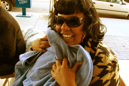 
                    Dawn participated in the very first Free Conversation Booth.  She loved it, and keeps coming back. Here she snuggles in one of the blankets that Simmons provides on cold days.
                                            (Ekene Okobi)
                                        