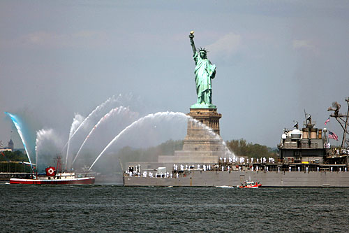 
                    The USS Monterey gets a watery salute from a fire boat as they pass the Statue of Liberty during a parade of ships on the first of eight days of Fleet Week in New York City.
                                            (Spencer Platt/Getty Images)
                                        