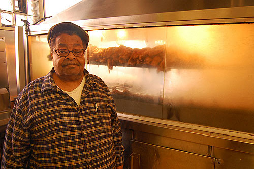 
                    James Lemons of Lem's Bar-B-Q in front of his "aquarium-style" meat smoker.
                                            (Amy C. Evans)
                                        