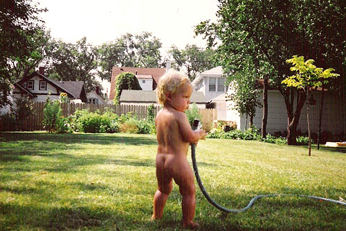 
                    Weekend America contributor Nanci Olesen's son Henry plays with the hose in their yard as a baby in 1991.
                                            (Nanci Olesen)
                                        