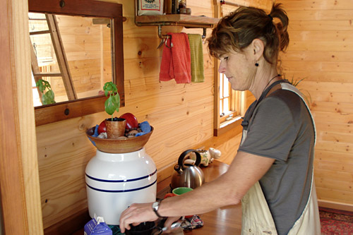 
                    Tiny houses have tiny kitchens and no plumbing. The sink empties into glass jar which Williams empties into her garden. The refrigerator is a cooler filled with ice and is kept outside.
                                            (Joshua McNichols)
                                        