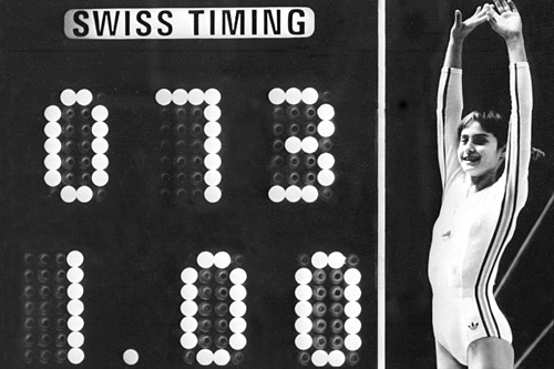 
                    Romanian Olympic gymnastics champion Nadia Comaneci celebrates as the scoreboard shows her perfect score for a routine on the uneven bars during the 1976 Olympic Games in Montreal.
                                            (AFP/Getty Images)
                                        