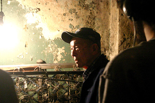 
                    Eddie Sano, in the basement where he worked as a kid. Next to him is an old boxspring from the hotel.
                                            (David Weinberg)
                                        