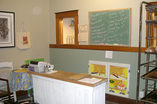 
                    A green board at the Back Alley counter lists the bread available to customers each day.
                                            (Martin Wells)
                                        