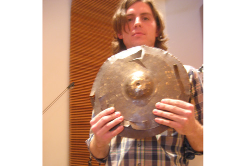 
                    Broken Cymbal: Eric Hall shows off what some might consider to be a trashed cymbal.  To NOMO, it's part of their sound.
                                            (Angela Kim)
                                        
