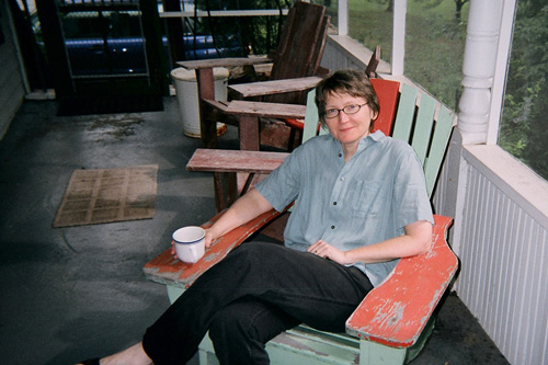 
                    The graphic designer and writer Sarah Micklem takes a break on the big house's porch.
                                            (Cornelius Eady)
                                        
