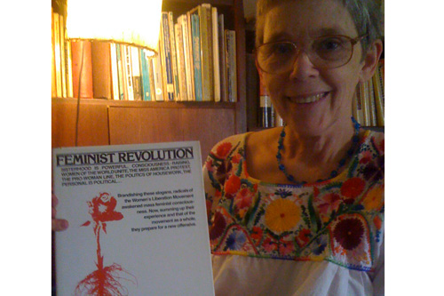 
                    Kathie Sarachild (Amatniek) holds up the one of the history books published by her organization Redstockings.  Part of the group's mission includes the Archives for Action, which documents the literature of the radical feminist movement and making it available for distribution.
                                            (Ann Heppermann)
                                        