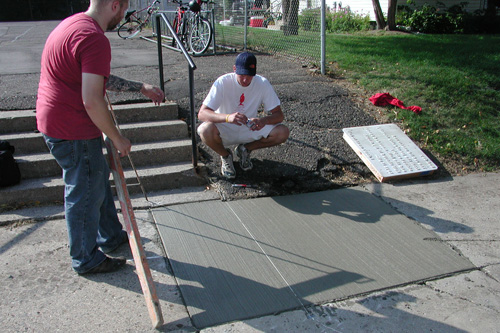 
                    The wet concrete is measured for placement of the mold for the poem "Bad day."
                                            (Chris Roberts)
                                        