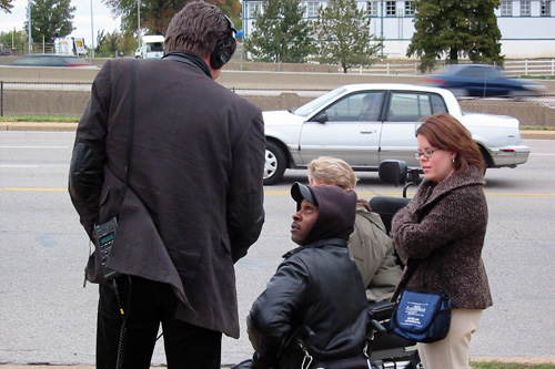 
                    Reporter Rick Karr waits for the bus with the Paraquad Staff.
                                            (Kristina Cafarella)
                                        