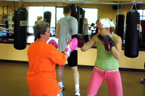 
                    Mary Yeman and coach Kristy Follmar spar off during boxing class. During this drill, Yeman hits Follmar's hand pads.
                                            (Colleen Iudice)
                                        