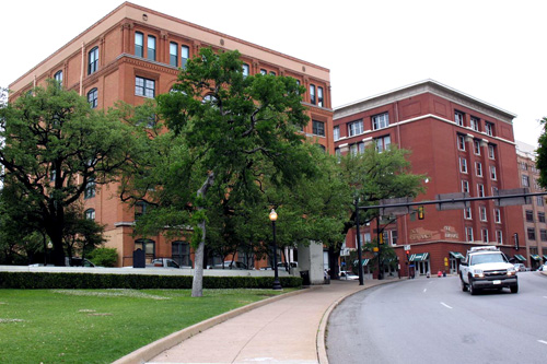 
                    The former Texas Schoolbook Depository building, now housing Dallas County offices and the Sixth Floor Museum. The "sniper's nest" is on the far right above the tree which has no nickname.
                                            (Julia Barton)
                                        