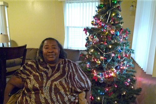 
                    Helen Hatcher sits next to her Christmas tree. She and her sister Charnita have planned a menu for Christmas that includes homemade desserts and freshly baked bread.
                                            (Desiree Cooper)
                                        