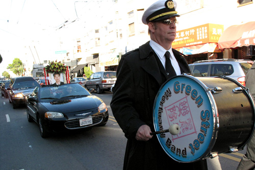 
                    Tim Vaughn plays bass drum for the Green Street Mortuary Band. The picture car and hearse follow the band, leading the mourners through the streets.
                                            (Julie Caine)
                                        