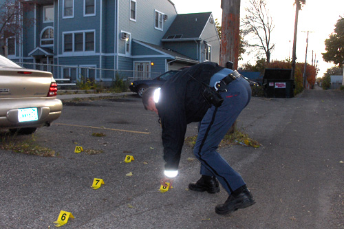 
                    Officer Lundquist flags spent shell casings from a crime scene.
                                            (Marc Sanchez)
                                        