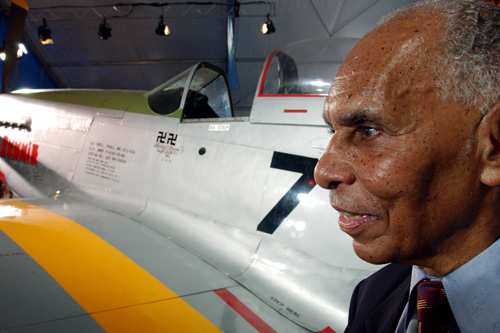 
                    Captain Roscoe C. Brown stands next to the actual P-51 Mustang he flew as a member of the Tuskegee Airmen as part of a celebration ceremony honoring the 100th anniversary of the Wright brothers' flight. The two swastikas painted on the plane's side symbolize two Nazi planes he shot down during his 68 combat missions.
                                            (Stephen Chernin/Getty Images)
                                        