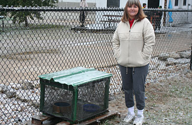 
                    Sheila Smith stands next to a feral cat feeding station that her organization, Shadowcats, has built.
                                            (Michael May)
                                        