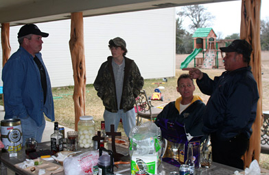 
                    Guests hanging out around the table outside at Major Alan Hahn's going away BBQ. The boy in the middle is Jarrett Salter, Matt's son.
                                            (Michael May)
                                        