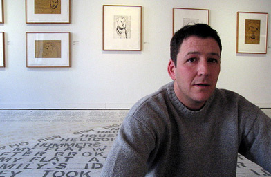 
                    Artist Daniel Heyman sitting in the middle of his new show of works at the Print Center in Philadelphia.
                                            (Joel Rose)
                                        