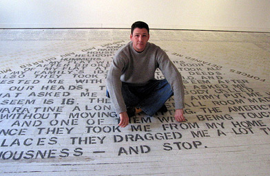 
                    Heyman sitting on text from his show "Abu Ghraib Detainee Interview Project." The text on the floor is taken from interviews with former detainees.
                                            (Joel Rose)
                                        