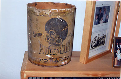 
                    An antique cannister of "bigger hair tobacco."  Earlier incarnations of this brand were called "n---ger hair tobacco."  Joe and Romana got most of their objects at antique stores and estate sales in Wisconsin and Minnesota.
                                            (Krissy Clark)
                                        