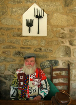 
                    Bobby sitting in the kitchen table with his own rendition of "American Gothic" hanging above him.
                                            (Ann Heppermann)
                                        