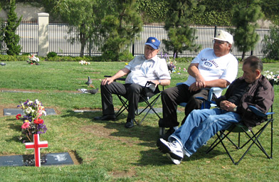 
                    Tony Vasquez tends to the graves, surrounding his mother's. He trims the grass, polishes them, tidies up. He serves as almost an ambassador to the area, comforting people in grief.
                                            (Suzie Lechtenberg)
                                        