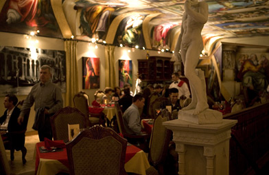 
                    Under Paco Rosic's aerosol interpretation of the Sistine Chapel, guests at his restaurant and gallery dine. The walls display smaller works on canvas that are for sale.
                                            (Sarah Mercier)
                                        