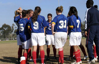 
                    The girls huddle with their coach.
                                            (Scott Carrier)
                                        