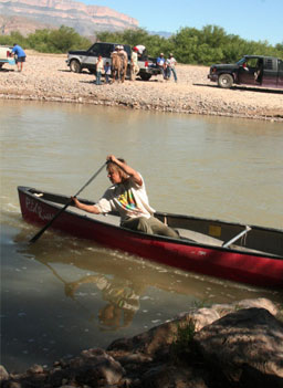 
                    Cynta De Narvaez canoes across the river. The men from Boquillas wait on the other side with trucks and a horse to bring the goods to town.
                                            (Michael May)
                                        