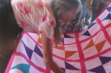 
                    De Narvaez examines quilts to decide whether or not to bring them across to sell.
                                            (Michael May)
                                        