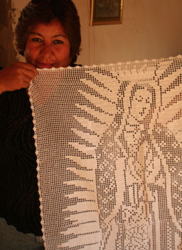 
                    Maria De La Luz and her Virgen De Guadalupe wall hanging.
                                            (Michael May)
                                        